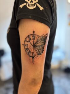 時計と蝶々のタトゥーの写真